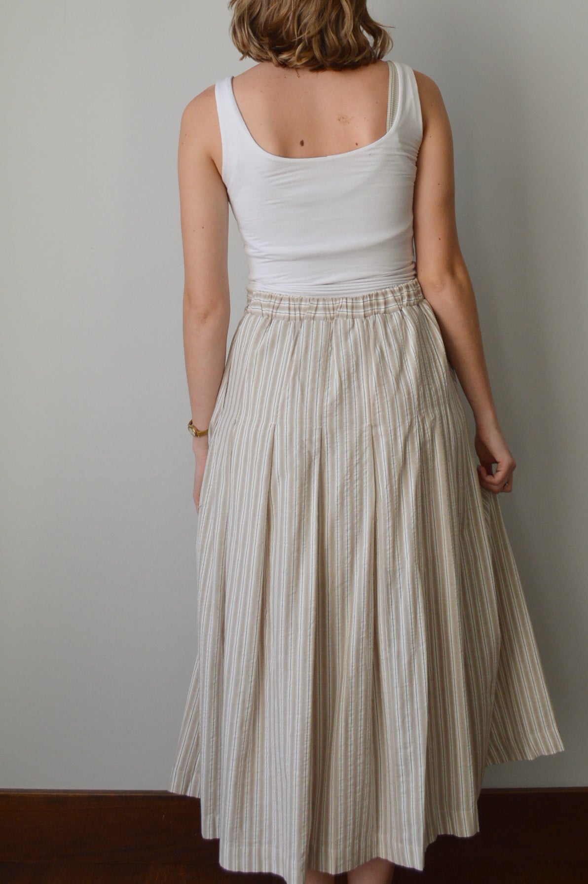 Woman wearing a striped skirt against a plain background