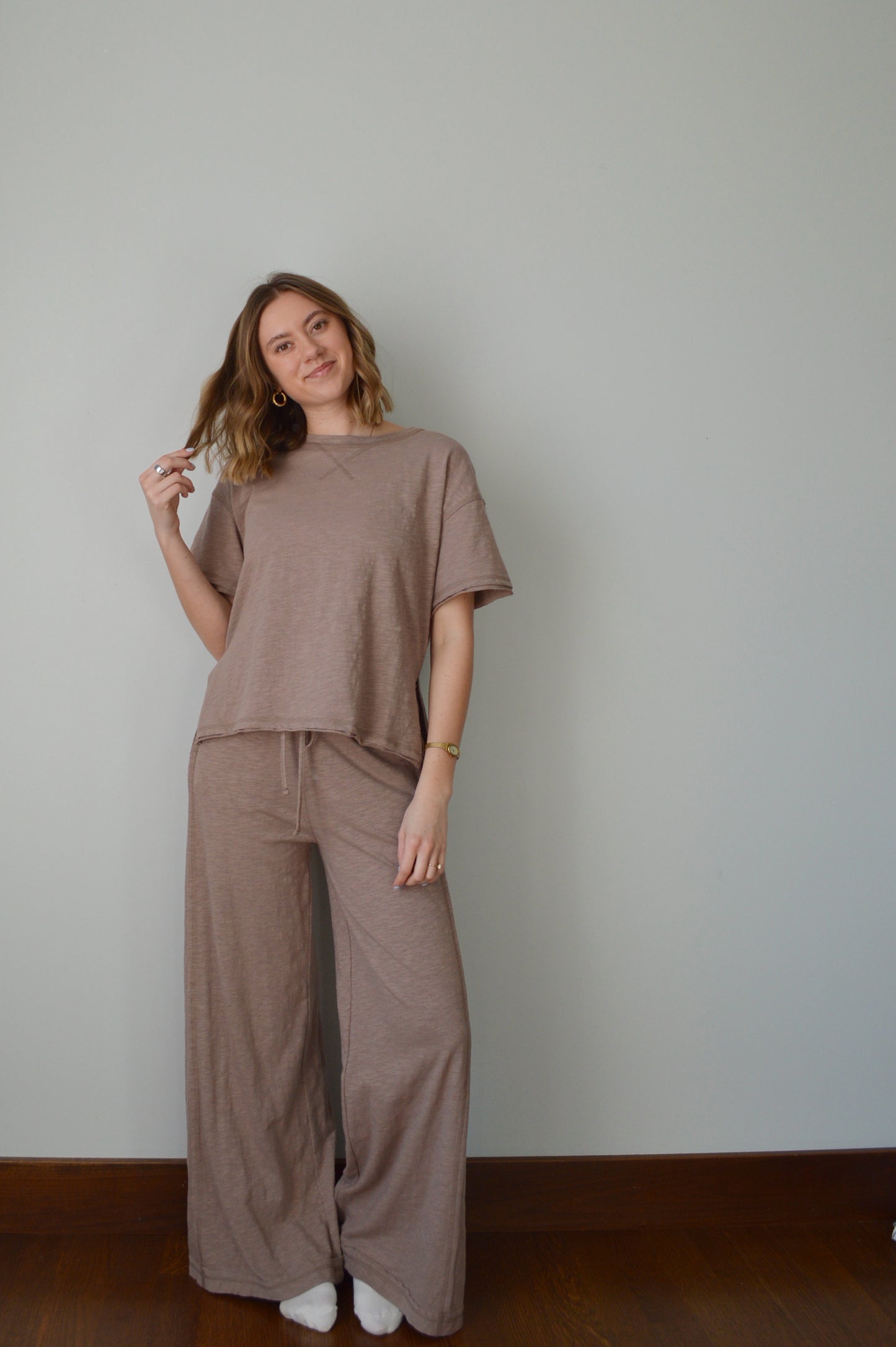 Woman wearing a brown outfit against a plain background