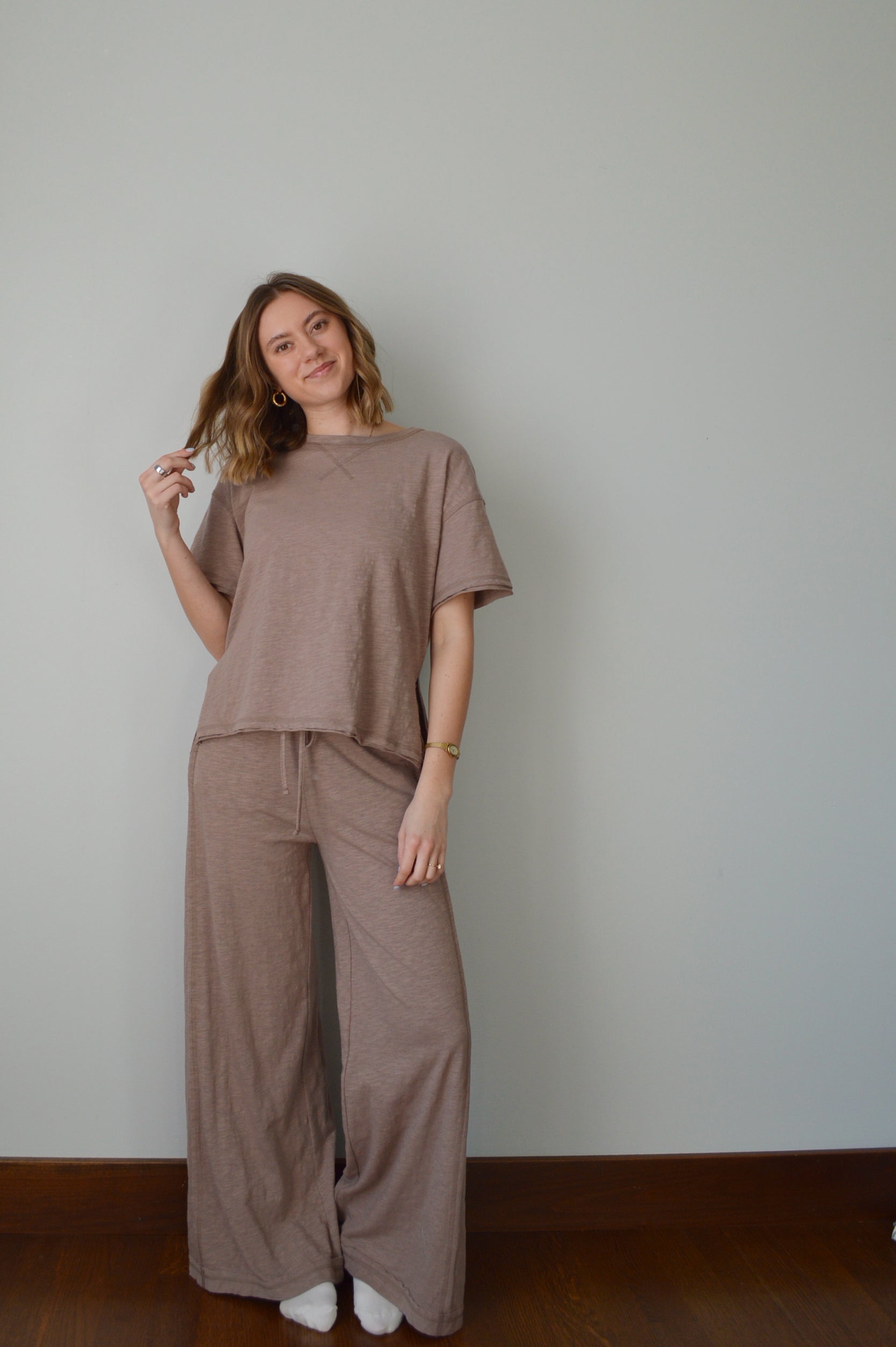 Woman wearing a brown outfit against a plain background
