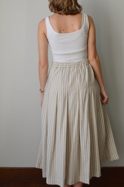 Woman wearing a striped skirt against a plain background
